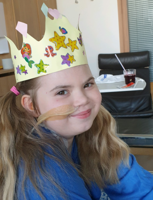 Tyttö sairaalassa hymyilee kruunu päässä